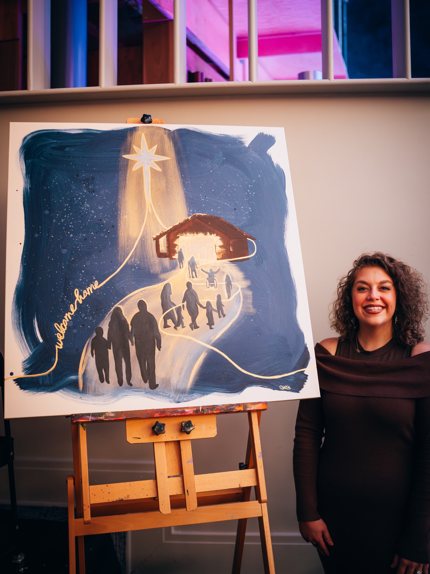 woman standing next to a nativity painting